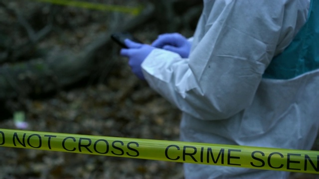 犯罪现场专家在案发现场的平板电脑上输入数据，收集证据视频素材