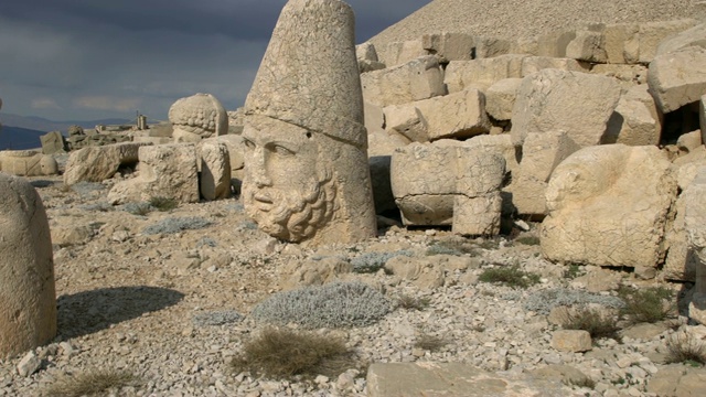 神像的头部和身体散落在涅姆鲁特山(涅姆鲁特Dağı)的西部梯田，土耳其东南部视频下载