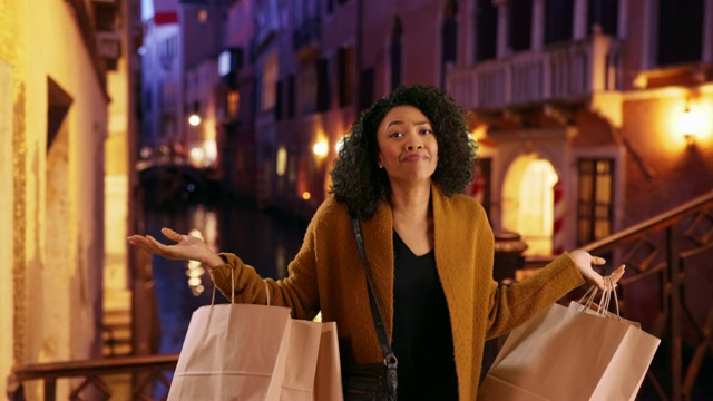 时尚的年轻黑人妇女在威尼斯旅游购物，在夜晚的欢乐跳舞视频素材