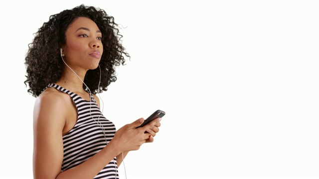 漂亮的非洲女人在手机上听着歌，在录音室里闭着眼睛视频素材