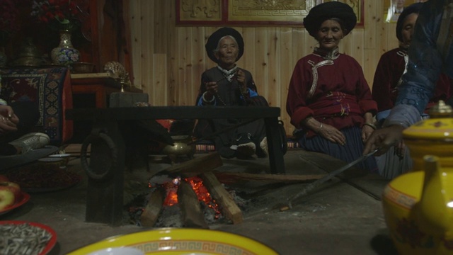 摩梭妇女围坐在火堆旁喝茶视频素材
