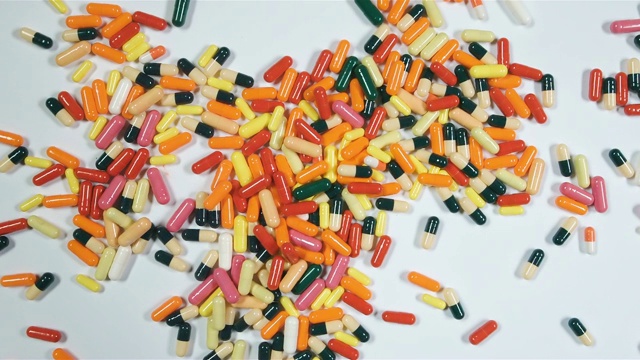 有很多有色药丸或毒品的背景。桌子上有很多药。急救箱里有药片。药学与医学。视频素材