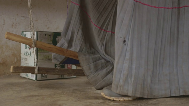 摩梭女子使用手工编织装置，特写镜头视频素材