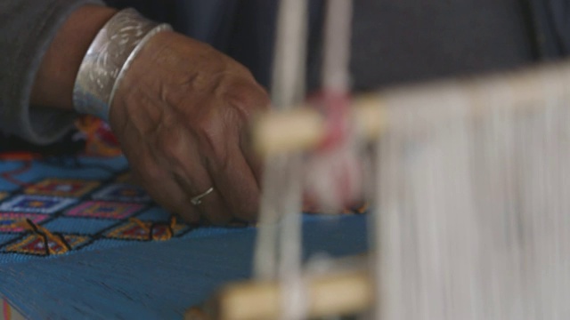 摩梭妇女使用手工编织装置，特写视频下载