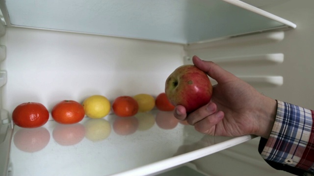 男人选择了冰箱里的水果，他选择了一个多汁的苹果视频下载