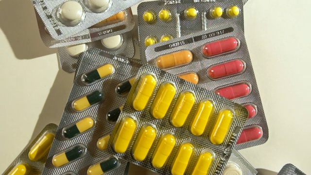 有很多有色药丸或毒品的背景。桌子上有很多药。急救箱里有药片。药学与医学。视频素材