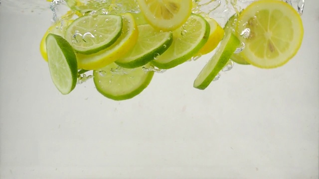 柠檬片和柠檬片落入水中，溅起水花，冒出气泡，这是慢镜头特写视频下载