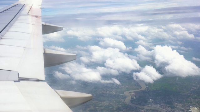 4k镜头的场景看窗外看到美丽的风景山，从飞机飞过的天空看到云，旅游和交通的概念视频素材
