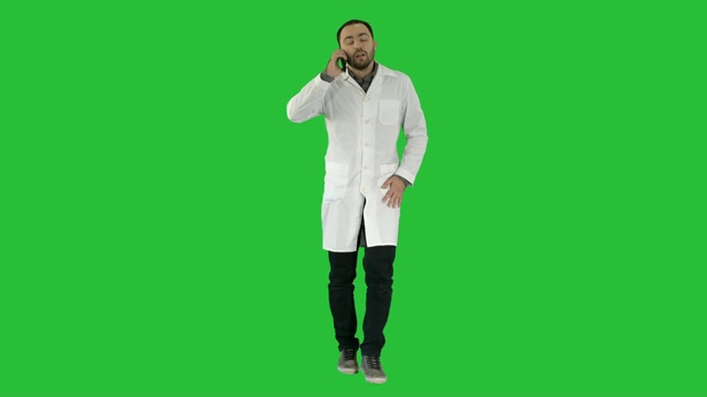 男医生一边走路一边用绿色屏幕打电话，颜色键视频素材