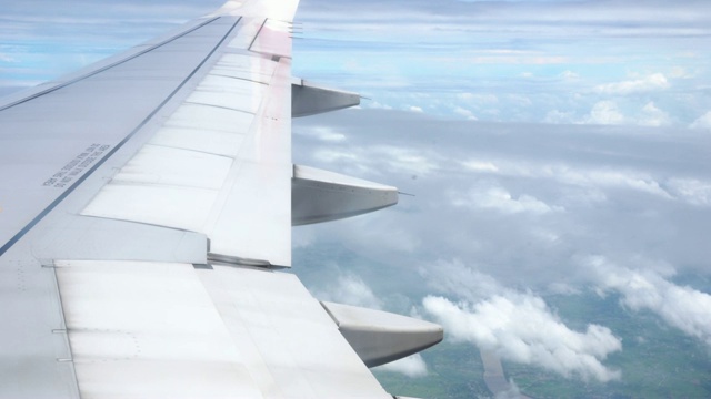 4k镜头的场景看窗外看到美丽的风景山，从飞机飞过的天空看到云，旅游和交通的概念视频素材