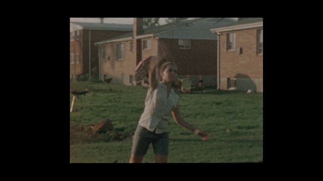 1956年，男孩和女孩在郊区的后院抛球视频素材