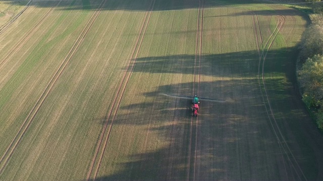 拖拉机在田间喷洒秋季作物，架空视频素材