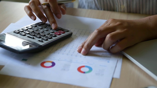 近距离观察商业女性会计用计算器计算财务数据表，商业和财务概念视频素材