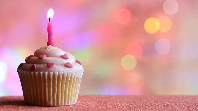 生日纸杯蛋糕和蜡烛上彩色散焦背景派对的概念视频素材