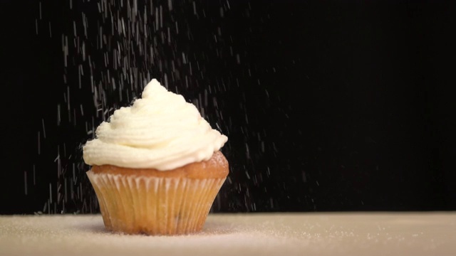 糕点洒在纸杯蛋糕的糖霜上。慢动作视频下载