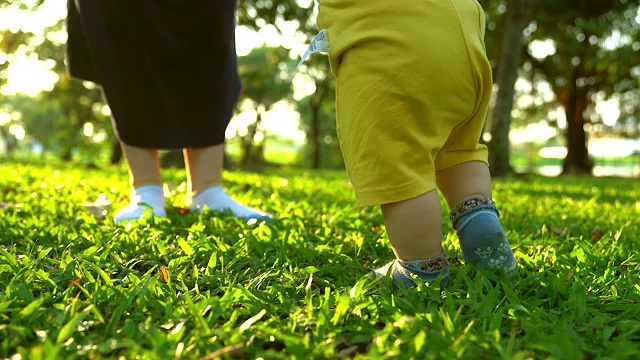 婴儿第一次踏在草地上。独立的第一步。视频素材