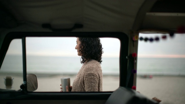年轻女子站在她的货车旁喝咖啡视频素材