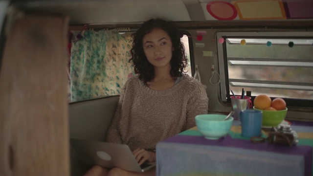 一名年轻女子开着露营车上路旅行视频素材