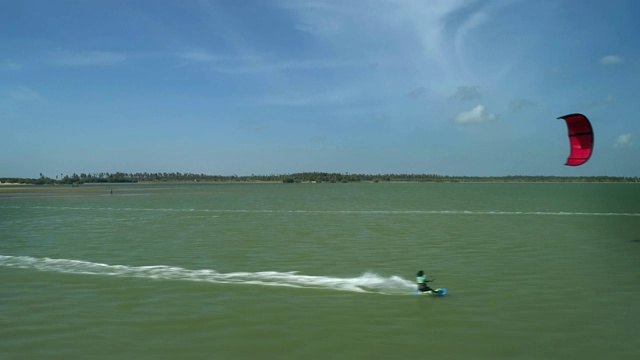 在斯里兰卡卡尔皮蒂亚的泻湖上，风筝滑板在令人惊叹的蓝色水上冲浪的空中超摄视频素材