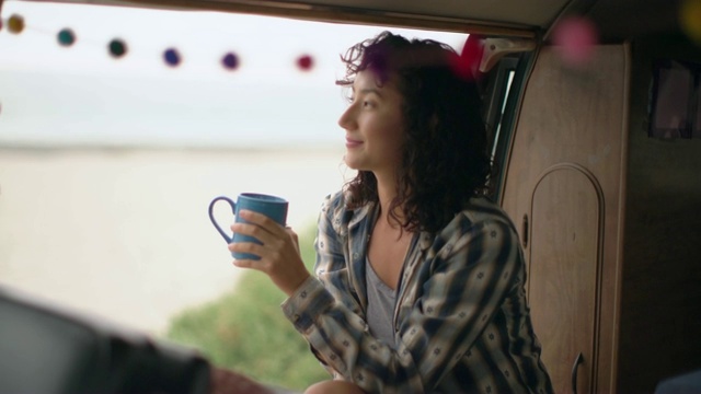 一名年轻女子开着露营车上路旅行视频素材