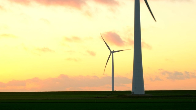 日落时分，海风公园里的风力涡轮机叶片在风中转动视频素材