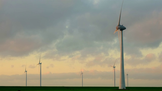 日落时分，海风公园里的风力涡轮机叶片在风中转动视频素材