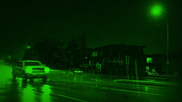 夜视车在大雨中经过房屋视频下载
