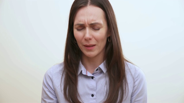 一个长头发的黑发女人坐在镜头前哭泣的特写视频素材