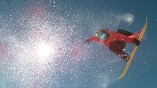 镜头耀斑明亮的阳光照耀在滑雪板跳跃踢和做一个戏法视频素材