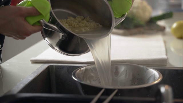 煮意大利面。用水槽里的漏勺把通心粉水沥干视频素材