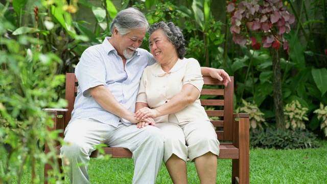 老夫妇一起坐在家里的花园里聊天。视频下载