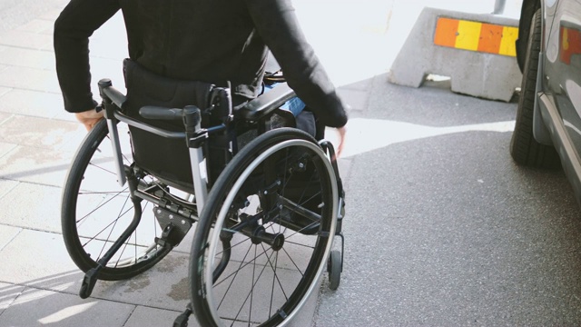 残疾妇女坐在轮椅上下汽车的腹部视频下载