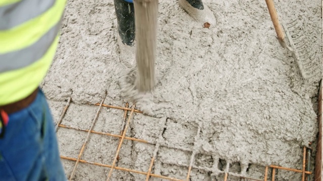 工人们在钢网上浇筑混凝土视频素材