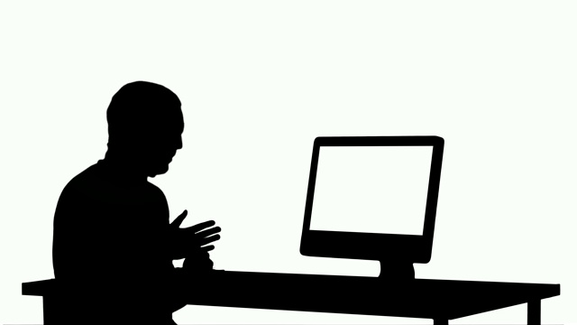 剪影年轻的商人在他的电脑上进行视频通话视频素材