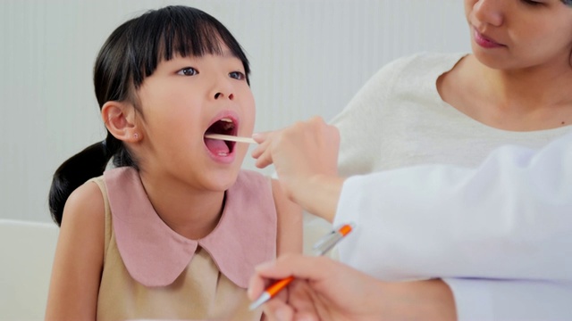 医疗咨询:儿科医生检查可爱的微笑亚洲女孩，喉咙病视频素材
