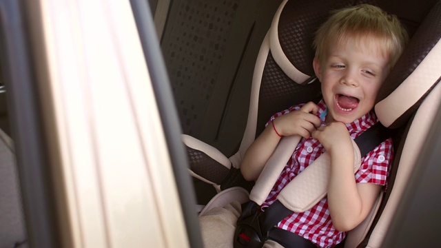 一个快乐的男孩在一个夏天旅行的儿童座椅上的肖像。视频素材