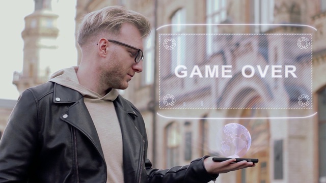 聪明的年轻人戴着眼镜展示了一个概念全息图游戏结束视频下载