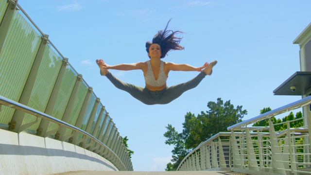 年轻的女舞者在一座桥上跳舞视频下载