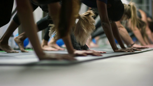 一群多民族的妇女在他们的二十多岁伸展下狗瑜伽姿势在一个健身工作室视频下载
