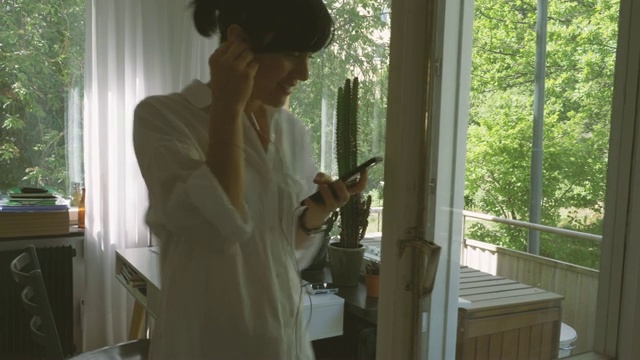 女商人在家门口用耳机讨论手机在家庭办公室视频素材