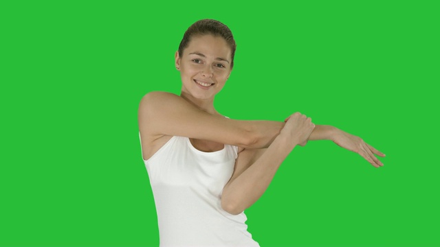 女人快乐的微笑女人伸展手臂，而行走在绿色屏幕上，色度键视频下载