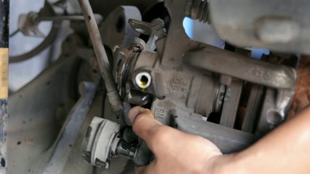 汽车修理工在维修站工作，修理起重汽车的车轮、刹车片和蹄片视频素材
