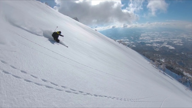 慢动作:跟在一位职业自由式滑雪者后面下山。视频素材