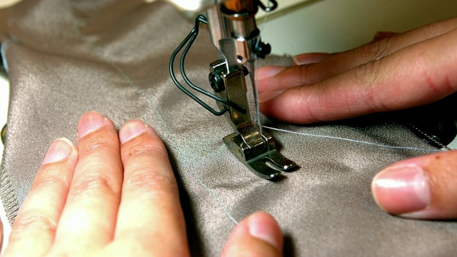 女裁缝在缝纫机上缝布视频下载