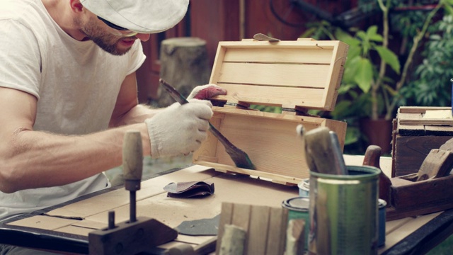 花园DIY。男人打磨木制家具。视频素材