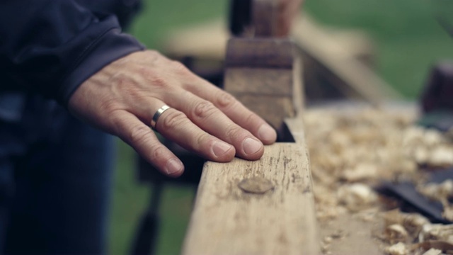 花园DIY。男人打磨木制家具。特写镜头。视频素材