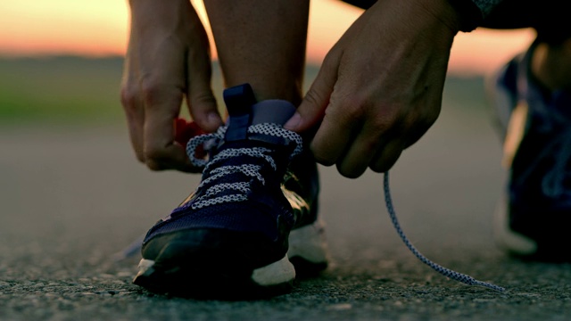 在跑步鞋上系鞋带的女人视频素材