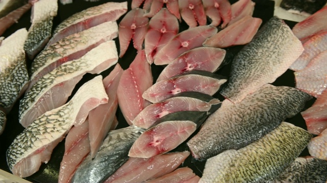 4K鱼市柜台上不同的新鲜生鱼切片视频下载