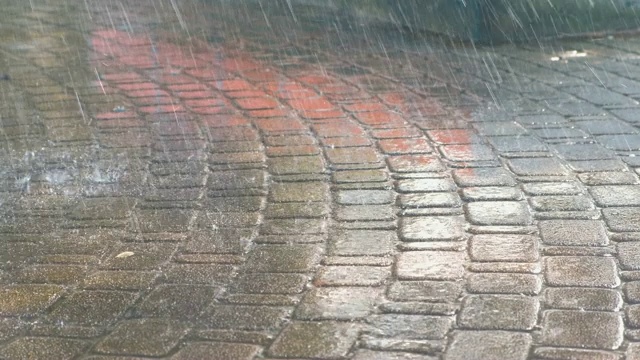 几滴大雨落在人行道上。视频素材