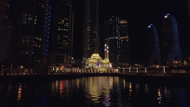 迪拜码头美丽的小清真寺夜景，从漂浮的游船上看视频下载